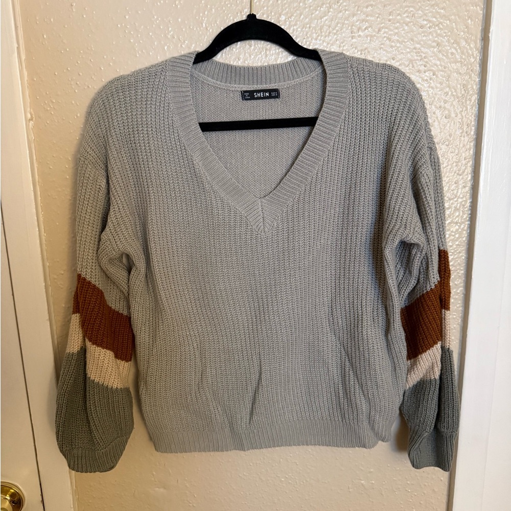 Product is a grey, thin/short sweater.